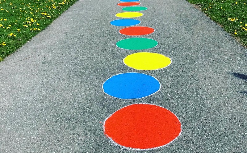 Målade färgglada ringar på en asfalterad gångväg